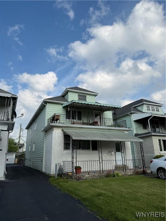 189 Lovering Ave, Buffalo, NY 14216 - view of front of house with a front lawn, a balcony, covered porch, and brick siding