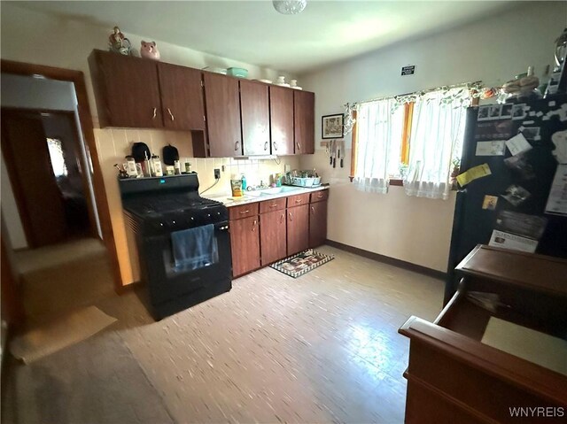 189 Lovering Ave, Buffalo, NY 14216 - kitchen with black appliances, a sink, light wood-style floors, baseboards, and light countertops