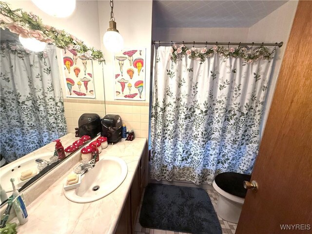 189 Lovering Ave, Buffalo, NY 14216 - bathroom featuring vanity, toilet, and tile walls