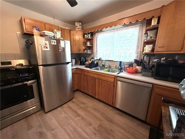 189 Lovering Ave, Buffalo, NY 14216 - kitchen with open shelves, appliances with stainless steel finishes, a sink, light countertops, and light wood-type flooring