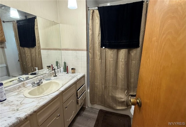 189 Lovering Ave, Buffalo, NY 14216 - full bathroom featuring tile walls, vanity, wood finished floors, and shower / bath combo with shower curtain