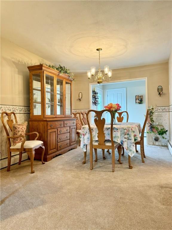 119 Park Ter, Big Flats, NY 14845 - dining area featuring a chandelier, light colored carpet, wallpapered walls, wainscoting, and a baseboard heating unit