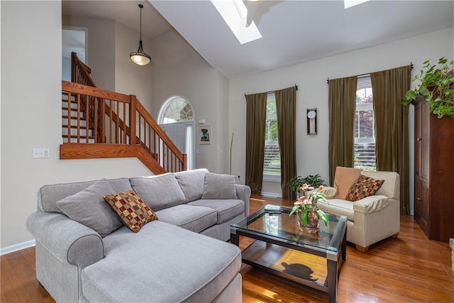 1108 Brick Landing Pl, Webster, NY 14580 - living room with healthy amount of natural light, a skylight, stairs, high vaulted ceiling, and wood-type flooring