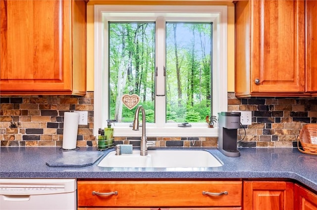 41 Pond Valley Cir, Penfield, NY 14526 - kitchen featuring dishwasher, a sink, brown cabinets, dark countertops, and backsplash