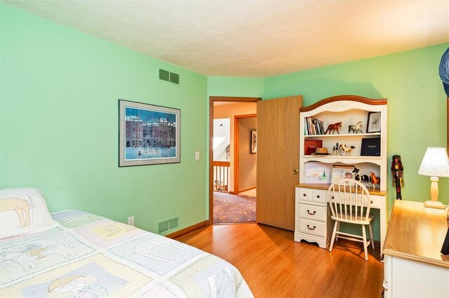 41 Pond Valley Cir, Penfield, NY 14526 - bedroom with wood finished floors, a desk, and a textured ceiling