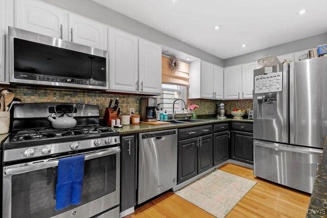 622 Stinard Ave, Syracuse, NY 13207 - kitchen with stainless steel appliances, a sink, white cabinetry, dark countertops, and recessed lighting