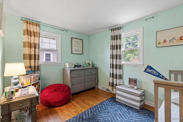 622 Stinard Ave, Syracuse, NY 13207 - bedroom featuring multiple windows, wood finished floors, and baseboards