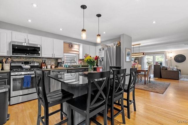 622 Stinard Ave, Syracuse, NY 13207 - kitchen featuring appliances with stainless steel finishes, a breakfast bar area, white cabinetry, decorative backsplash, and recessed lighting