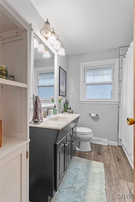 622 Stinard Ave, Syracuse, NY 13207 - full bath with vanity, wood finished floors, toilet, baseboards, and a shower with shower curtain
