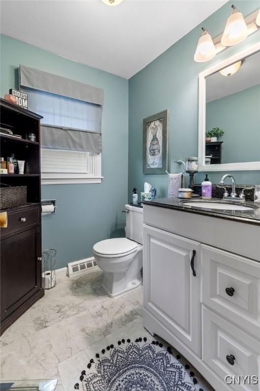 622 Stinard Ave, Syracuse, NY 13207 - bathroom with vanity, marble look tiles, and toilet