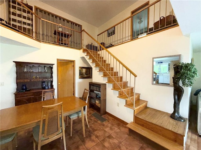 1476 Grange Hall Rd, Junius, NY 14532 - dining area featuring stairway, a towering ceiling, tile patterned flooring, and baseboards