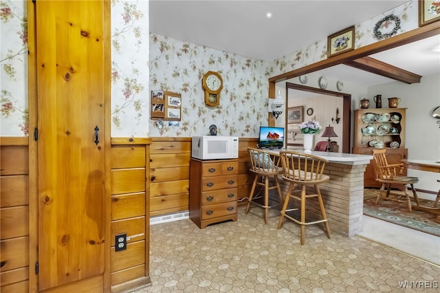 131 Idlewood Dr, Aurora, NY 14127 - bar area featuring white microwave, wallpapered walls, a wainscoted wall, and light flooring