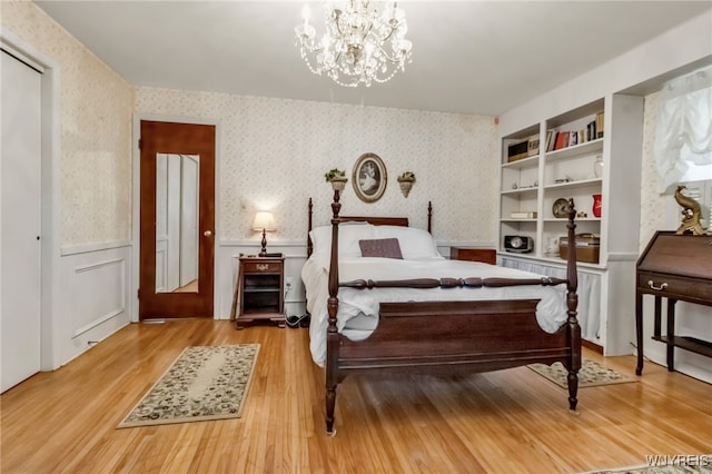 131 Idlewood Dr, Aurora, NY 14127 - bedroom featuring wainscoting, wallpapered walls, light wood finished floors, and a chandelier