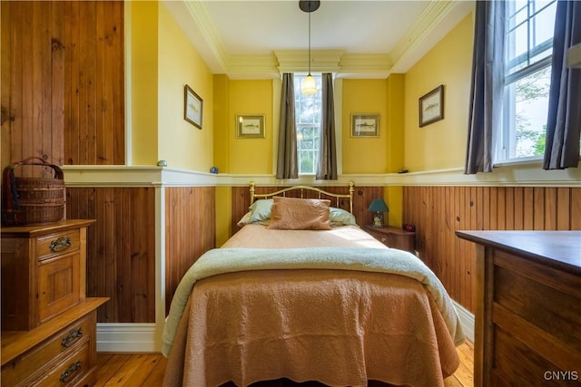 28 Bridge St, Albion, NY 13302 - bedroom featuring wainscoting, multiple windows, ornamental molding, wood finished floors, and wood walls