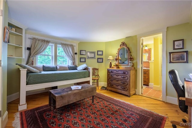 28 Bridge St, Albion, NY 13302 - bedroom with light wood-type flooring, baseboards, and connected bathroom