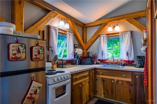 28 Bridge St, Albion, NY 13302 - kitchen with freestanding refrigerator, white electric range oven, a sink, lofted ceiling, and plenty of natural light