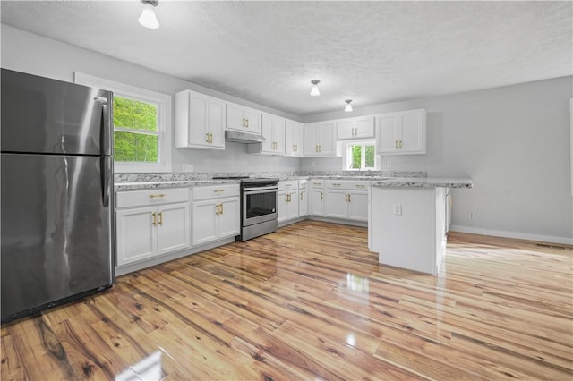 10610 State Route 7, Worcester, NY 12149 - kitchen featuring appliances with stainless steel finishes, under cabinet range hood, healthy amount of natural light, white cabinetry, and a textured ceiling