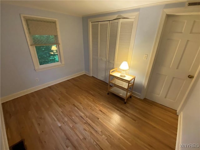 5780 Sheridan Dr, Amherst, NY 14221 - unfurnished bedroom featuring wood finished floors, a closet, and baseboards