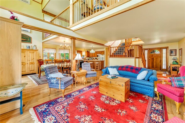 2555 County Highway 22, Richfield, NY 13439 - living room with a chandelier, a towering ceiling, wood finished floors, stairway, and a wall unit AC