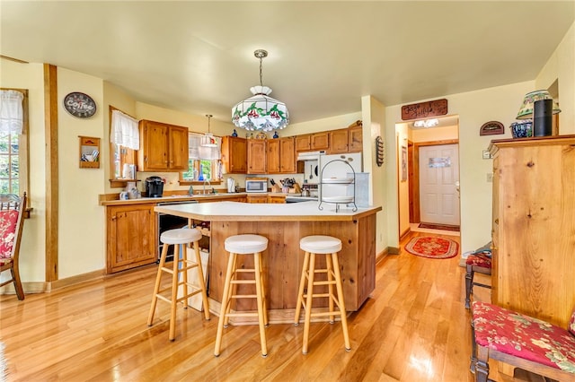 2555 County Highway 22, Richfield, NY 13439 - kitchen with dishwashing machine, light wood-style floors, light countertops, and a breakfast bar
