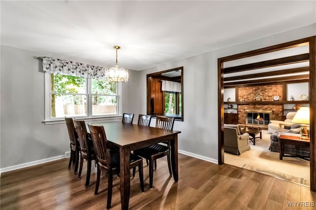 4640 Pine Mnr Unit W, Clarence, NY 14031 - dining area with a chandelier, wood finished floors, baseboards, and a brick fireplace
