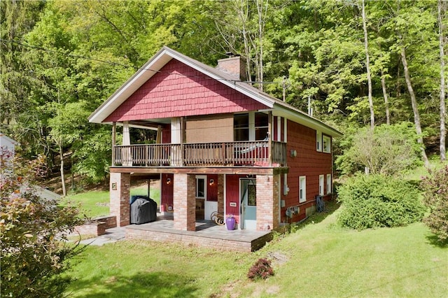 25 Woodside Ave, Oneonta-City, NY 13820 - rear view of property featuring a chimney, a lawn, and a view of trees
