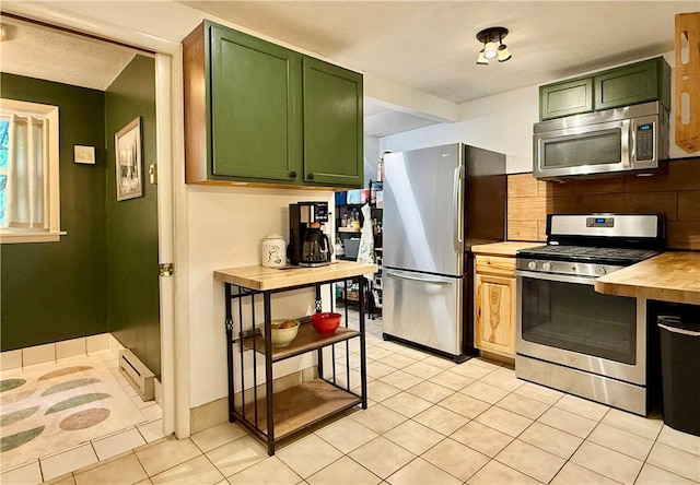 25 Woodside Ave, Oneonta-City, NY 13820 - kitchen with stainless steel appliances, green cabinetry, a baseboard heating unit, light tile patterned floors, and tasteful backsplash