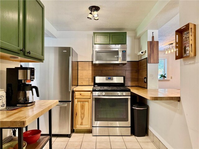 25 Woodside Ave, Oneonta-City, NY 13820 - kitchen featuring stainless steel appliances, green cabinets, butcher block countertops, light tile patterned floors, and decorative backsplash