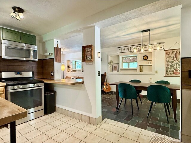 25 Woodside Ave, Oneonta-City, NY 13820 - kitchen with appliances with stainless steel finishes, green cabinetry, tasteful backsplash, a textured ceiling, and light tile patterned flooring