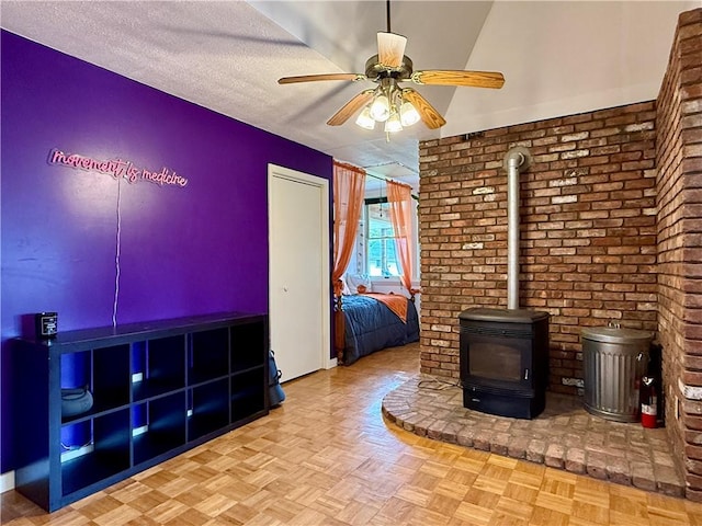 25 Woodside Ave, Oneonta-City, NY 13820 - unfurnished living room featuring a ceiling fan, a wood stove, and a textured ceiling