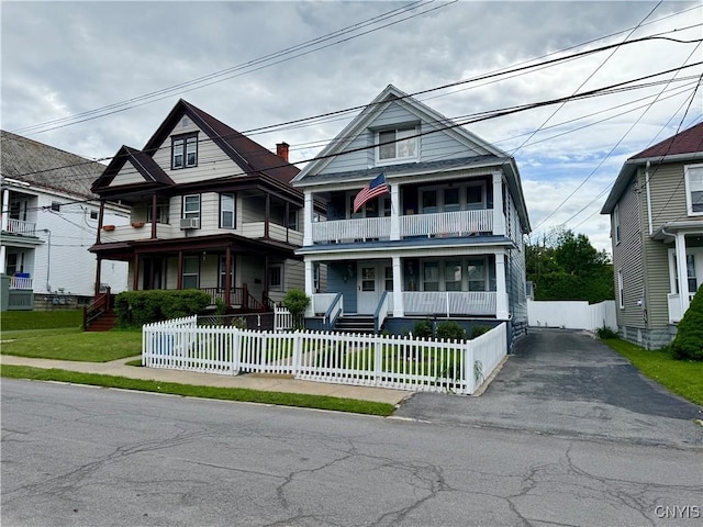 32-30 Kenyon Ct Unit 30, Utica, NY 13501 - view of front of property with a porch, driveway, a fenced front yard, and a balcony