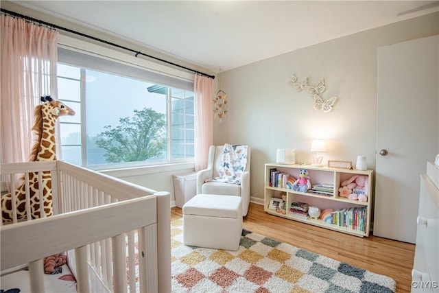 11245 Bell Hill Rd, Deerfield, NY 13502 - bedroom featuring wood finished floors and a nursery area