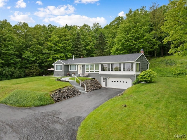 11245 Bell Hill Rd, Deerfield, NY 13502 - ranch-style house with asphalt driveway, an attached garage, a view of trees, and a front lawn