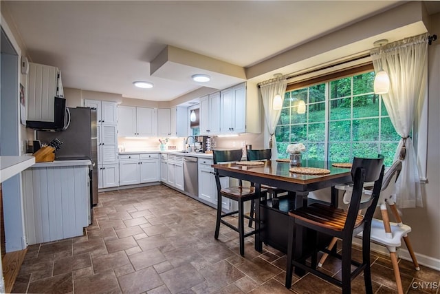 11245 Bell Hill Rd, Deerfield, NY 13502 - kitchen featuring dishwasher, a sink, stone finish floors, white cabinetry, and light countertops