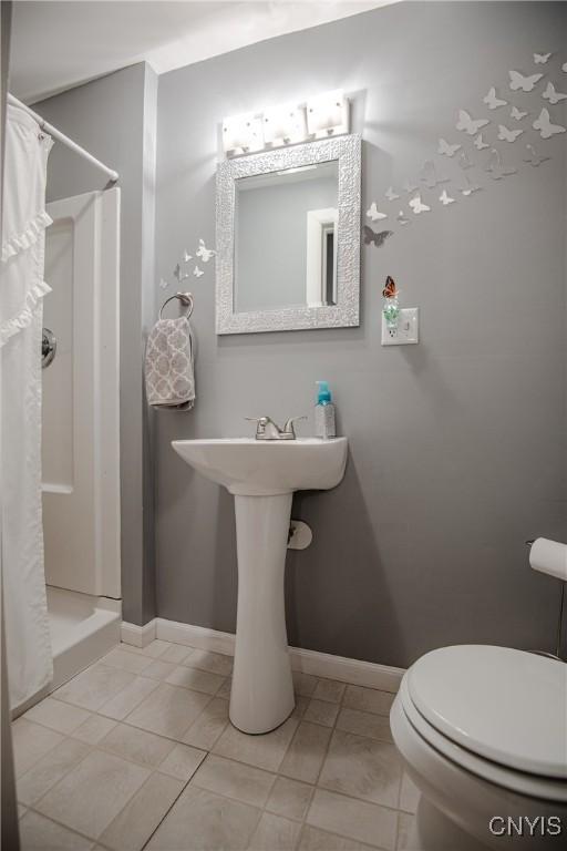 11245 Bell Hill Rd, Deerfield, NY 13502 - full bathroom featuring a stall shower, toilet, baseboards, and tile patterned flooring