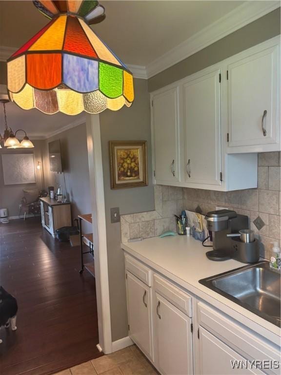 1056 Charlesgate Cir, Amherst, NY 14051 - kitchen with crown molding, white cabinets, light countertops, and a sink