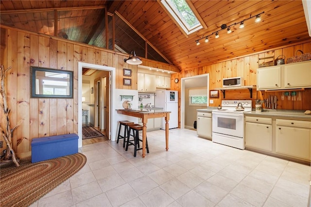 4255 Parish Hill Rd, Italy, NY 14512 - kitchen with white appliances, rail lighting, a skylight, vaulted ceiling, and wood walls