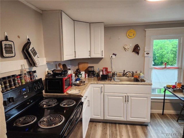 158 Keil St, North Tonawanda, NY 14120 - kitchen featuring black range with electric cooktop, a sink, white cabinetry, light wood-type flooring, and plenty of natural light