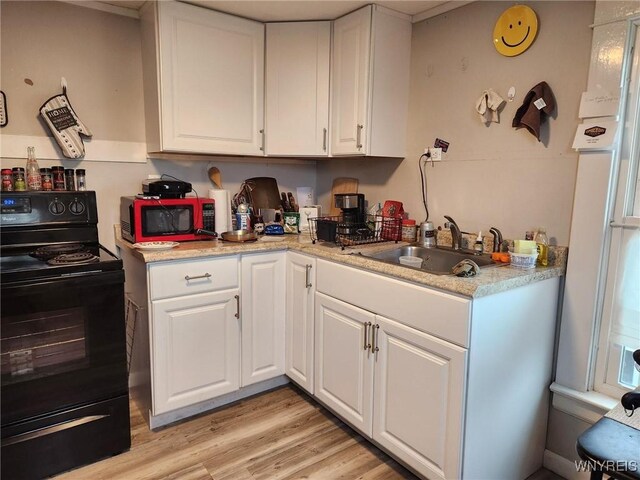 158 Keil St, North Tonawanda, NY 14120 - kitchen featuring black electric range, a sink, white cabinetry, and light countertops