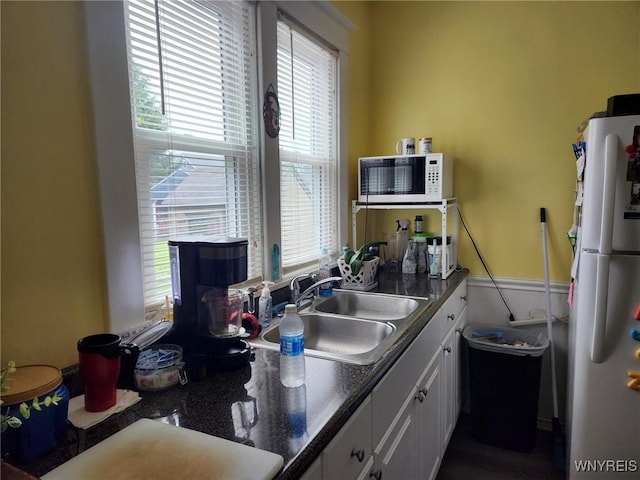158 Keil St, North Tonawanda, NY 14120 - kitchen with freestanding refrigerator, white cabinetry, a sink, and dark countertops