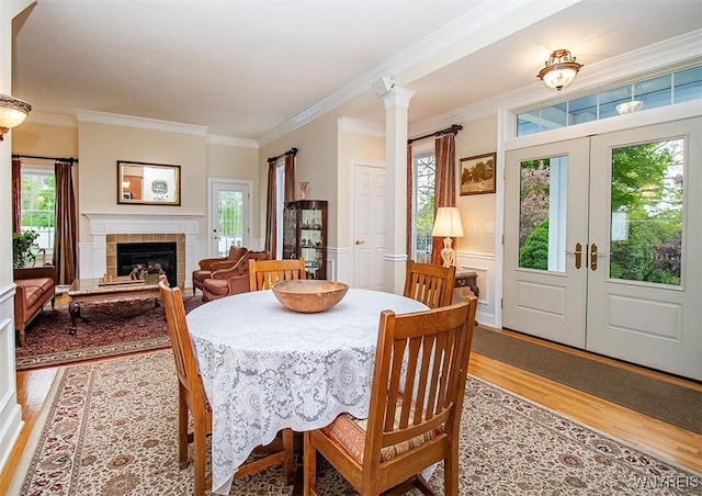 4786 Ormonde Dr, Cazenovia, NY 13035 - dining room with light wood-style flooring, french doors, ornamental molding, plenty of natural light, and a tiled fireplace