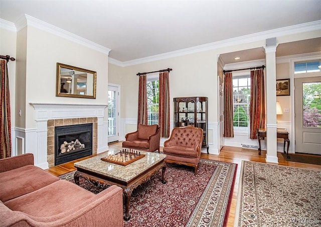 4786 Ormonde Dr, Cazenovia, NY 13035 - living room with wood finished floors, crown molding, wainscoting, a tile fireplace, and a decorative wall