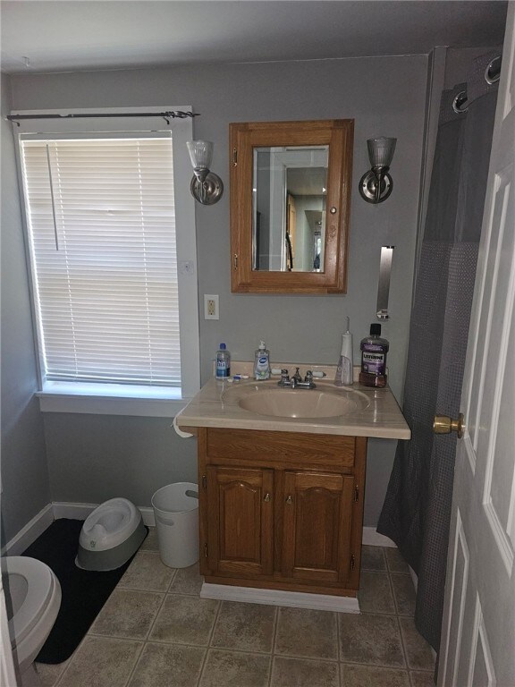 2968 County Highway 11, Hartwick, NY 13348 - bathroom with toilet, vanity, and tile patterned floors