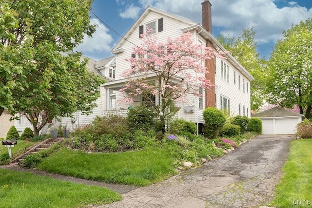 173 Mosley Dr Unit 1, Syracuse, NY 13206 - view of home's exterior featuring an outdoor structure, a chimney, and a detached garage