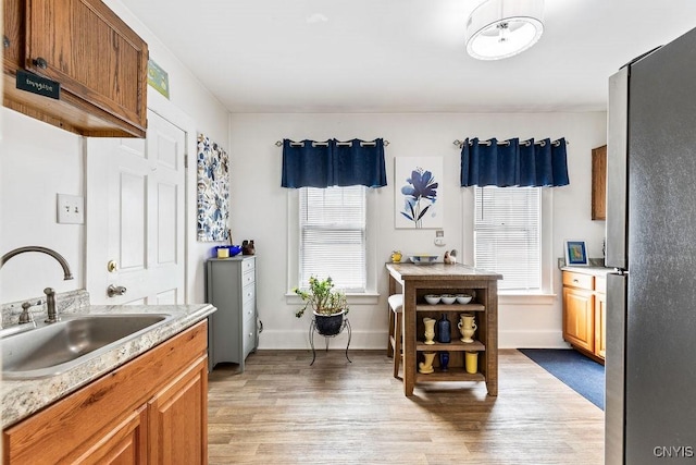 173 Mosley Dr Unit 1, Syracuse, NY 13206 - kitchen featuring a sink, freestanding refrigerator, light wood-type flooring, light countertops, and healthy amount of natural light