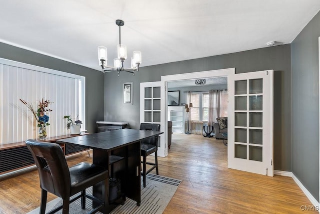 173 Mosley Dr Unit 1, Syracuse, NY 13206 - dining area featuring a chandelier, wood finished floors, french doors, and baseboards