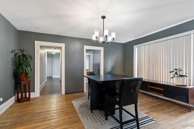 173 Mosley Dr Unit 1, Syracuse, NY 13206 - dining area with wood finished floors, a chandelier, and baseboards