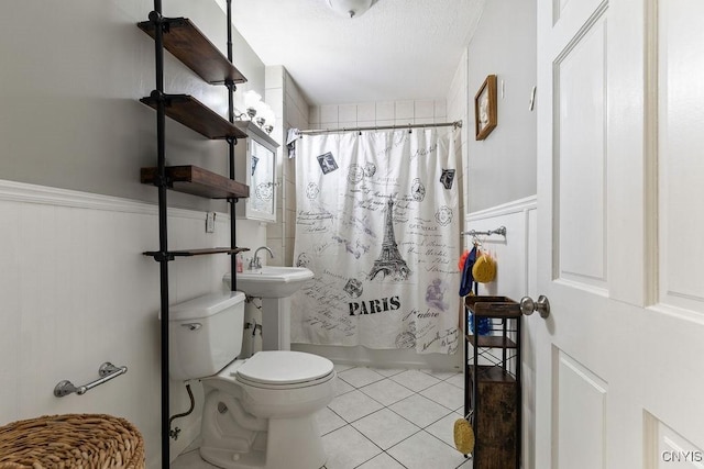 173 Mosley Dr Unit 1, Syracuse, NY 13206 - bathroom featuring tile patterned floors, toilet, wainscoting, shower / bath combo, and a textured ceiling