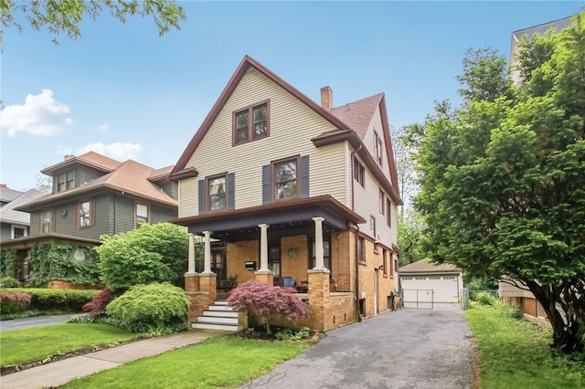 865 Harvard St, Rochester, NY 14610 - view of front of house with covered porch, a chimney, an outbuilding, a garage, and brick siding