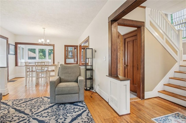 865 Harvard St, Rochester, NY 14610 - sitting room featuring stairs, light wood-style flooring, a chandelier, and a textured ceiling